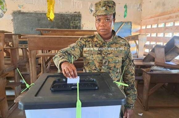 Une militaire glissant son bulletin dans l'urne ce 14 juillet 2025 dans un bureau de vote à Lomé...